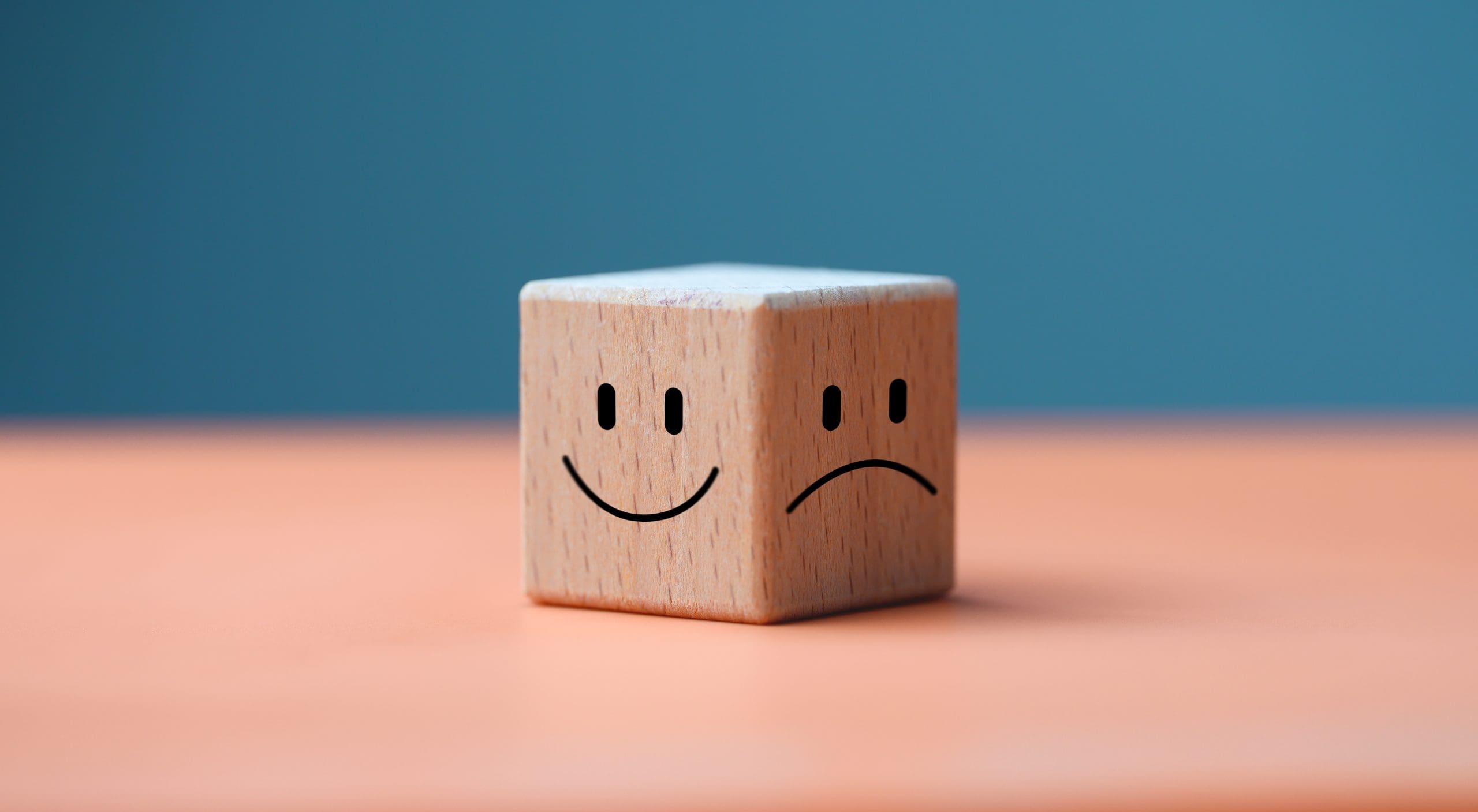 A wooden cube with a smiley face on it.