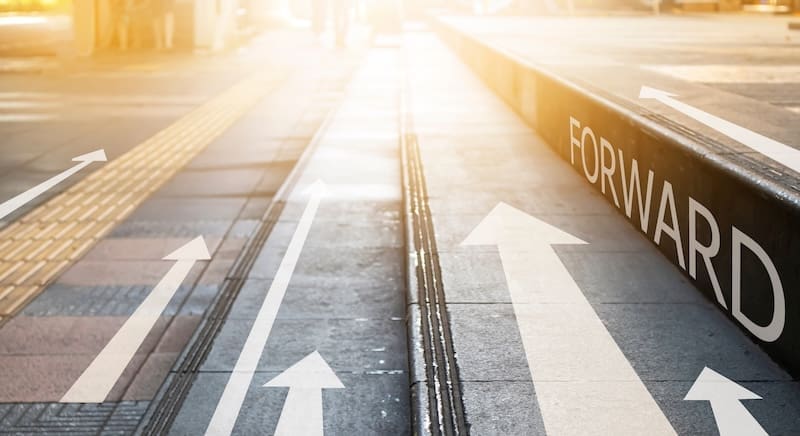 Several white arrows point ahead on a sunlit urban path, with the word "FORWARD" written on a curb, symbolizing progress and Reputation Repair as one moves confidently into the future.