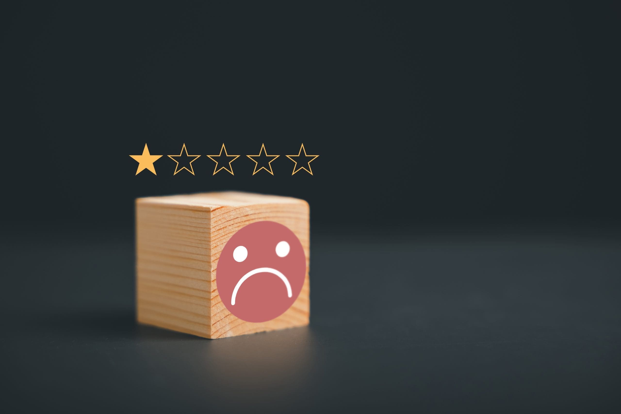 A wooden cube with a sad face and stars on it.