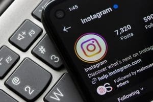 Instagram profile page displayed on a smartphone screen placed on a keyboard.