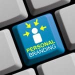 A blue keyboard key with a white person icon, yellow arrows pointing toward it, and the words "PERSONAL BRANDING" in yellow and white letters, surrounded by plain white keys.