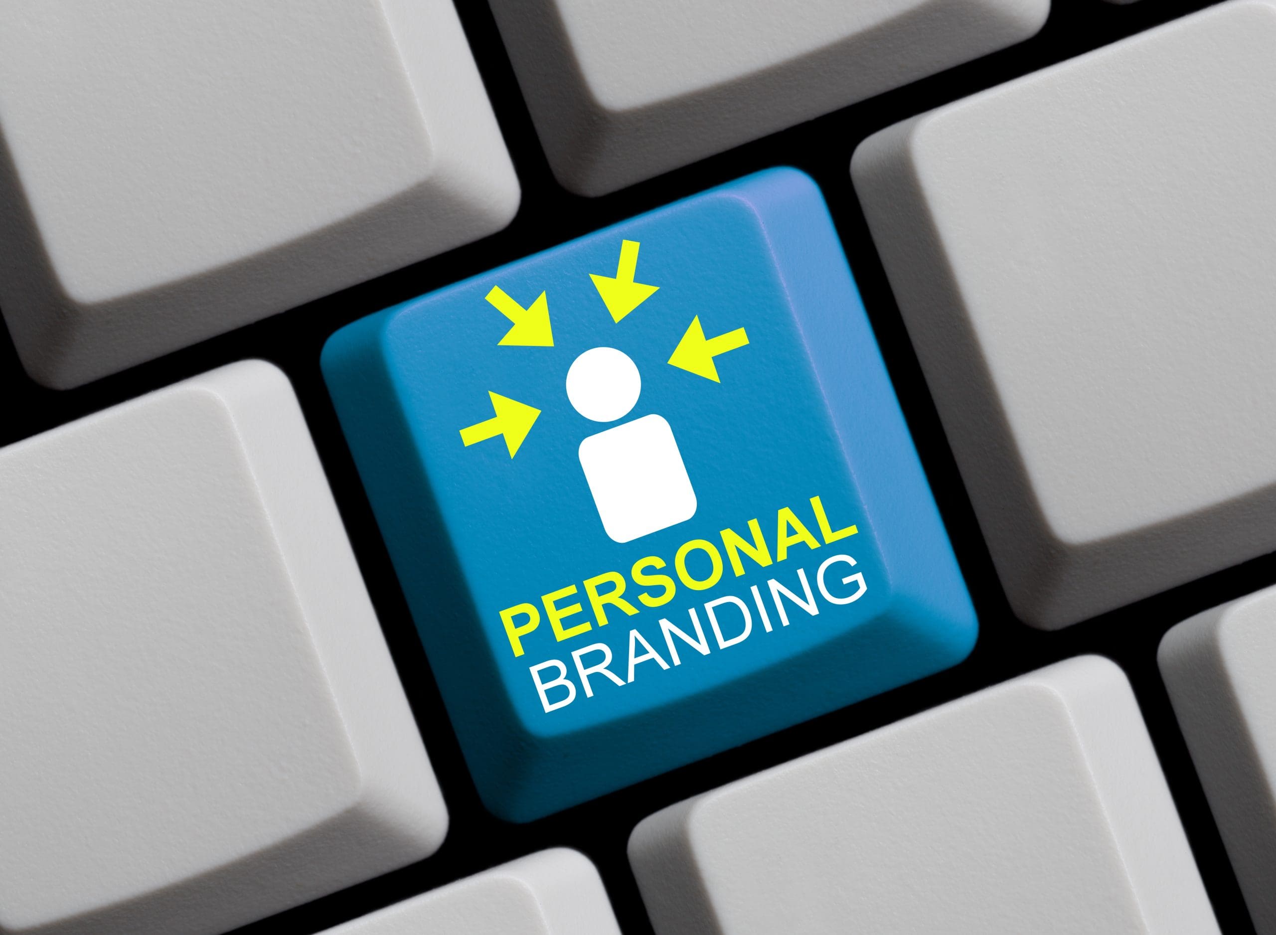 A blue keyboard key with a white person icon, yellow arrows pointing toward it, and the words "PERSONAL BRANDING" in yellow and white letters, surrounded by plain white keys.