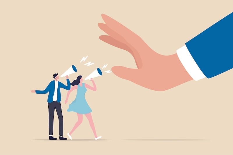 Illustration of a large hand stopping or silencing a man and woman shouting through megaphones, symbolizing censorship or suppression of free speech and control over illegal content.