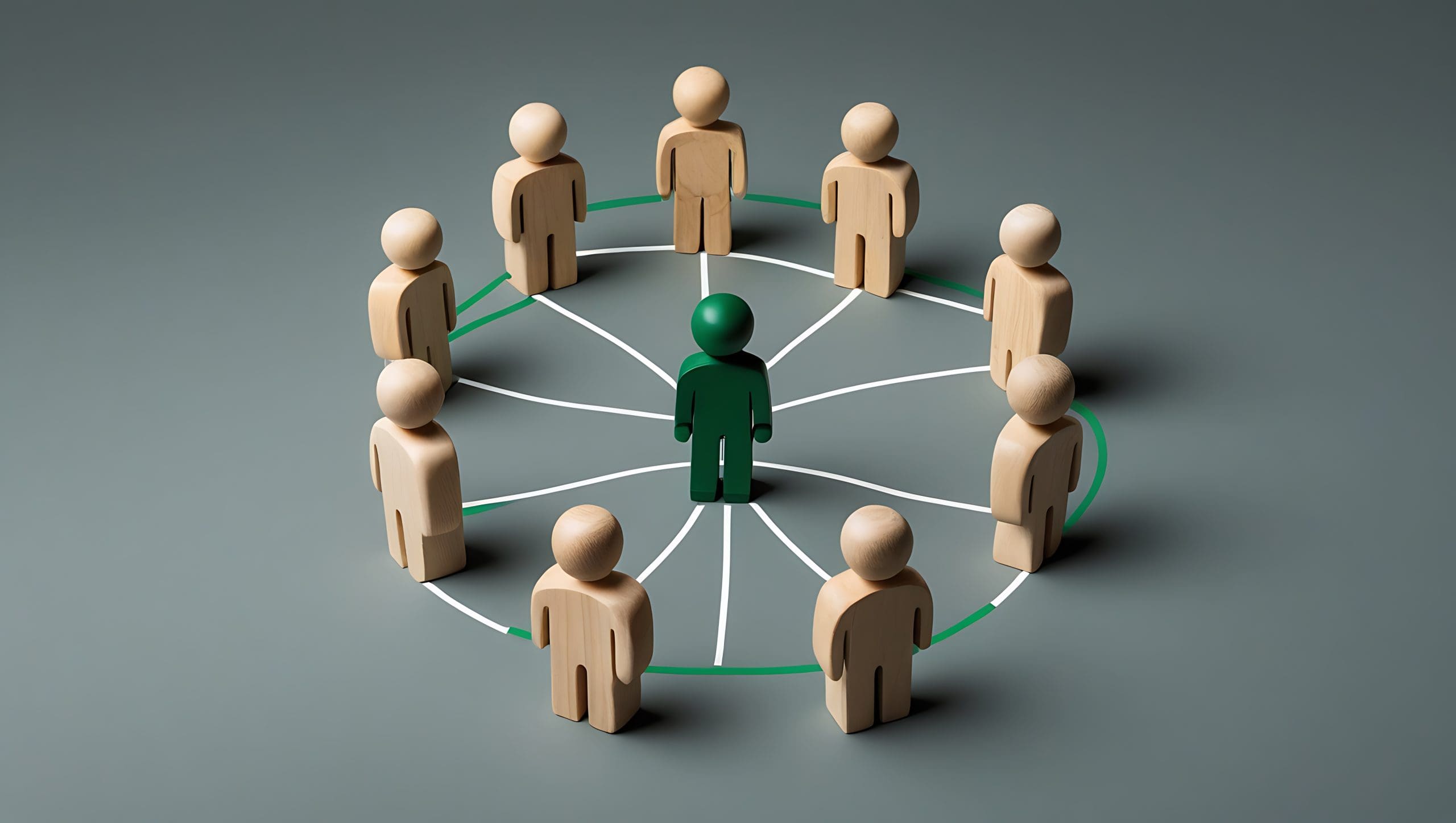 A group of wooden figures arranged in a circle surrounds a central green figure, with white lines connecting the central figure to each outer figure, representing networking or leadership.